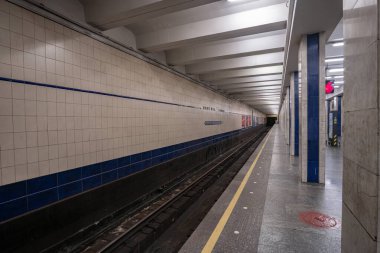 Poshtova Ploshcha metro istasyonunun içi. İstasyonda kare mermer sütunlar ve doğrusal floresan ışıklandırmadan oluşan bir sütunlu merkezi platform yer alıyor. Kyiv, Ukrayna - 29 Mart 2025.