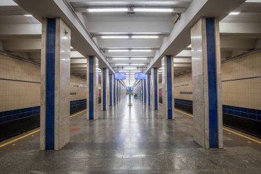 Poshtova Ploshcha metro istasyonunun içi. İstasyonda kare mermer sütunlar ve doğrusal floresan ışıklandırmadan oluşan bir sütunlu merkezi platform yer alıyor. Kyiv, Ukrayna - 29 Mart 2025.