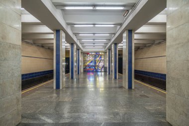 Poshtova Ploshcha metro istasyonunun içi. İstasyonda kare mermer sütunlar ve doğrusal floresan ışıklandırmadan oluşan bir sütunlu merkezi platform yer alıyor. Kyiv, Ukrayna - 29 Mart 2025.