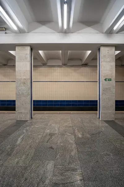 Poshtova Ploshcha metro istasyonunun içi. İstasyonda kare mermer sütunlar ve doğrusal floresan ışıklandırmadan oluşan bir sütunlu merkezi platform yer alıyor. Kyiv, Ukrayna - 29 Mart 2025.
