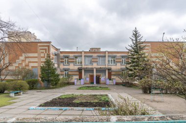 Yan duvarlarında dekoratif döşeme desenleri olan iki katlı bir anaokulunun ön bahçesi. Troieshchyna İlçesi, Kyiv, Ukrayna 6 Nisan 2025.