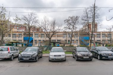 Mavi balkonları ve çizgili fayansları olan Sovyet döneminden kalma bir anaokulu manzarası. Arabalar ön tarafa park edilmiş. Troieshchyna İlçesi, Kyiv, Ukrayna 6 Nisan 2025.