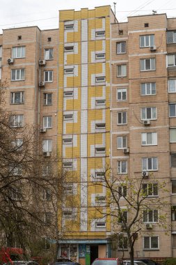 Ön cephesinde sarı ve beyaz kiremit desenleri olan bir panelin giriş bölümü. Troieshchyna İlçesi, Kyiv, Ukrayna 6 Nisan 2025.
