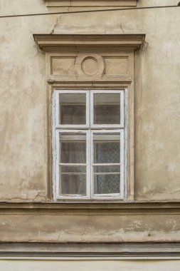 Eski beyaz ahşap pencere, dört kuşak ve eski bej dış cephesinde klasik kaplama..