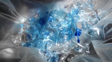 Geri dönüşüm için bir çantaya doldurulmuş mavi plastik şişeler. Dolly kaçar.