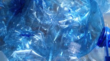 Geri dönüşüm için bir çantaya doldurulmuş mavi plastik şişeler. Dolly kaçar.