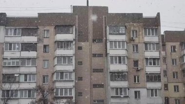 Kar yağışı sırasında kapalı balkonları olan 1990 'ların eski apartmanı. Kyiv, Ukrayna - 10 Nisan 2025