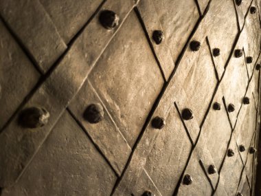 Dekoratif demir çivileri ve çapraz desenli eski metalik kapı, yakın plan..