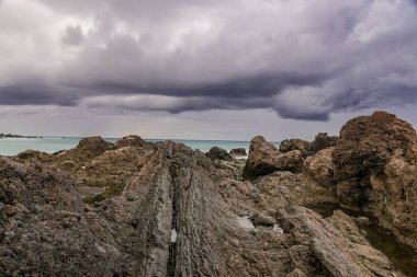 Atlantik Okyanusu, Puerto de la Cruz, Tenerife, Kanarya Adaları üzerinde kara yağmur bulutları ile kıyıda volkanik oluşum