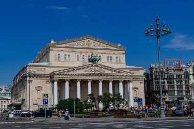 Moskova / Rusya; 22 Haziran 2019: Bolşoy tiyatrosu, güneş ışığı ve yürüyen insanlar ve mavi gökyüzü arka planı, Moskova, Rusya