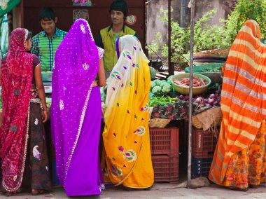Deorgah, Hindistan 8 Mart 2015: Kentin kalabalık pazar alanından tipik renkli Rajasthani elbiseli kadınlar meyve ve sebze satın alıyorlar