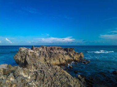 Cancun, Playa Gaviota 'nın kayalık kıyılarında çarpıcı bir gün batımı. Karayip dalgaları yavaşça kıyıya vuruyor.