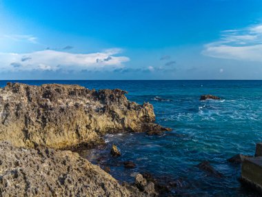 Cancun, Playa Gaviota 'nın kayalık kıyılarında çarpıcı bir gün batımı. Karayip dalgaları yavaşça kıyıya vuruyor.