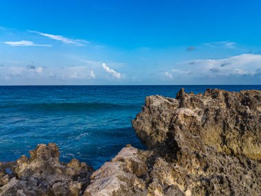 Cancun, Playa Gaviota 'nın kayalık kıyılarında çarpıcı bir gün batımı. Karayip dalgaları yavaşça kıyıya vuruyor.