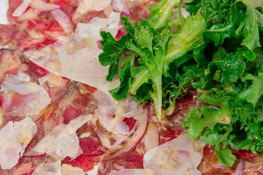 Peynirli börek ve taze marulla kaplı bir ton balıklı carpaccio 'nun zarif yakın çekimi. Bu gurme yemeği lüks yemek deneyimleri ve mutfak sunumları için mükemmel. Canlı renkler ve sofistike kaplamalar.