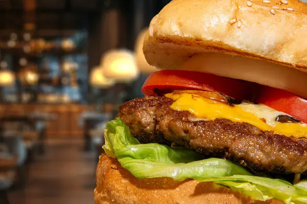 stock image Delicious mushroom burger topped with fresh tomato, onion, and melted cheese. Perfectly grilled and served on a classic bun, this gourmet burger offers a savory and satisfying meal experience for any burger lover