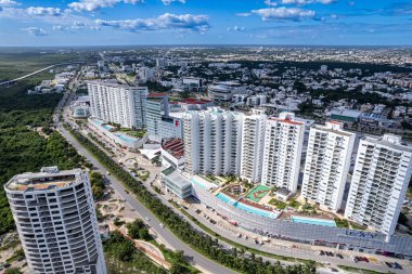 Stunning aerial perspective of Cancun city center, showcasing its proximity to the Nichupte Lagoon and the renowned Hotel Zone amidst a vibrant urban landscape. clipart