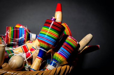 Siyah arka planda geleneksel ve zanaatkar Meksika oyuncakları sergilenen güzel düzenlenmiş bir sepet.