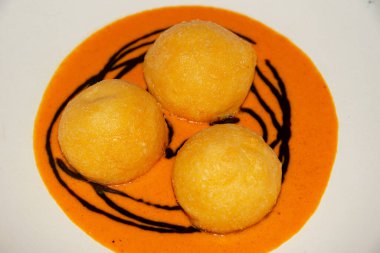 Exquisite parmesan spheres served with a rich and smoky roasted pepper sauce clipart