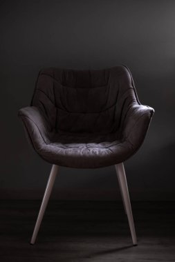 Yemek sandalyesi. Yumuşak bir sandalye. Sandalyenin silüeti. Rahat ev mobilyaları. Sırtı ve kollukları olan bir sandalye. Siyah beyaz fotoğraf. Bastırılmış ışıkta döşenmiş mobilyalar