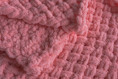 Knitted blanket. Homemade plush plaid. Gentle yarn. Scandinavian style. Warm clothes. Hygge in the interior.