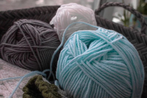 Close-up of skeins of woolen threads. Yarn of different colors. Home knitting. Cozy knitting hobby. Wool thread. Soft yarn. Knitted things.
