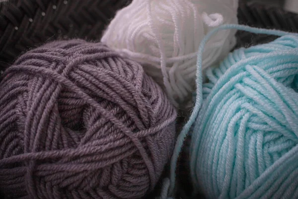 Close-up of skeins of woolen threads. Yarn of different colors. Home knitting. Cozy knitting hobby. Wool thread. Soft yarn. Knitted things.
