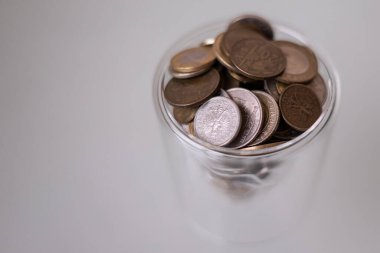 Arka planda farklı ülkelerin bakır para yığınlarının toplanması. Bir yığın bozuk para. Düşük maaş. Para biriktirmeyi. Parasızlık. Sikkelerin şıngırtısı. Ev bütçesi. Bakır paralar. Mali okuryazarlık.