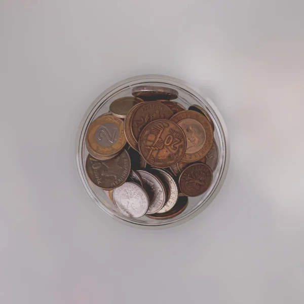 Collection of heaps of copper coins of different countries on a light background. A pile of coins. Small salary. How to save money. Lack of money. The jingle of coins. Household budget. Copper coins. Financial literacy.