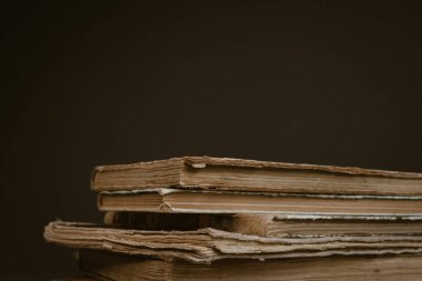 Yıpranmış omurgaları ve sarı sayfaları olan bir yığın eski kitap. Kitap sayfaları yaşlılıktan beri sarıdır. Bir sürü kitap. Bilginin kaynağı. Eski kütüphane. Klasik arka plan. Sarı sayfalar. Açık bir kitap. Eskimiş kitap dikenleri..
