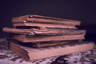 Yıpranmış omurgaları ve sarı sayfaları olan bir yığın eski kitap. Kitap sayfaları yaşlılıktan beri sarıdır. Bir sürü kitap. Bilginin kaynağı. Eski kütüphane. Klasik arka plan. Sarı sayfalar. Açık bir kitap. Eskimiş kitap dikenleri..