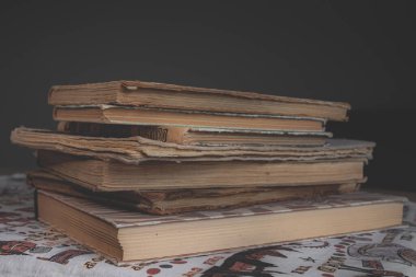 Yıpranmış omurgaları ve sarı sayfaları olan bir yığın eski kitap. Kitap sayfaları yaşlılıktan beri sarıdır. Bir sürü kitap. Bilginin kaynağı. Eski kütüphane. Klasik arka plan. Sarı sayfalar. Açık bir kitap. Eskimiş kitap dikenleri..