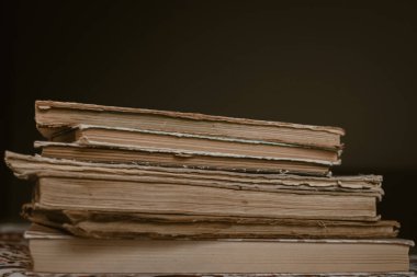 Yıpranmış omurgaları ve sarı sayfaları olan bir yığın eski kitap. Kitap sayfaları yaşlılıktan beri sarıdır. Bir sürü kitap. Bilginin kaynağı. Eski kütüphane. Klasik arka plan. Sarı sayfalar. Açık bir kitap. Eskimiş kitap dikenleri..