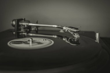 Fotoğraftaki pikaptaki plak plağı klasik tarzda. Vinil plak. Analog ses. DJ ekipmanları. Müzik aletleri. Vinil plak çalar. Ses kaydı.