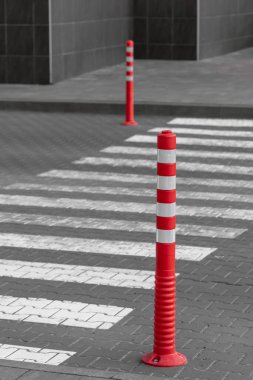 Boş yaya geçidi ve kauçuk sinyal direkleri. Kırmızı lastik sütun. Boş zebra. Yoldaki çizgiler. Yoldaki güvenlik. Yayalar için işaretler. Lastik sinyal direkleri. Yol işaretleri.