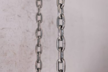 İki demir zincir dikey olarak arka planda asılı. Demir çekiş yapısı. Çelik zincir. Teker teker. Erkek geçmişi. Paralel çizgiler.