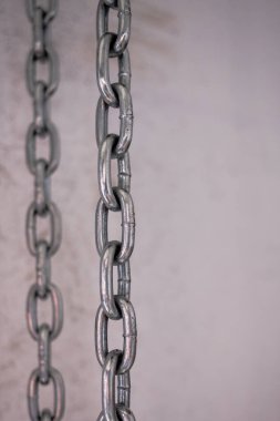 İki demir zincir dikey olarak arka planda asılı. Demir çekiş yapısı. Çelik zincir. Teker teker. Erkek geçmişi. Paralel çizgiler.