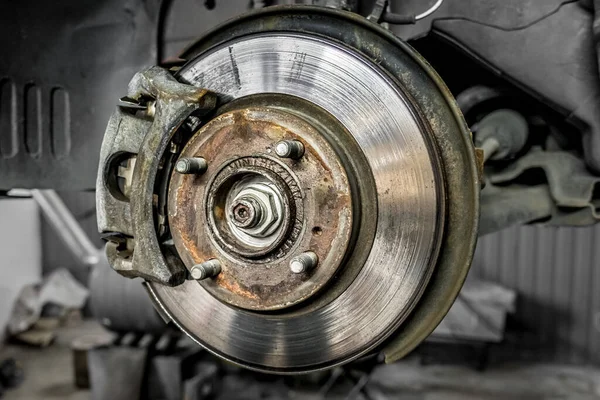 Brake pad on a car disc close-up. Car brake. Disassembled wheel. Disc without tire. Transport topic. Garage background. Replacing the brake box. Auto mechanic work.