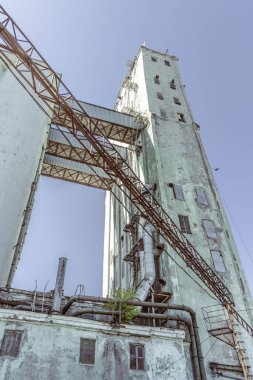 Eski terk edilmiş asansör binası. Yiyecek endüstrisi. Yüksek bir binanın alt manzarası. Eski asansör. Endüstriyel bir binanın ön cephesi.