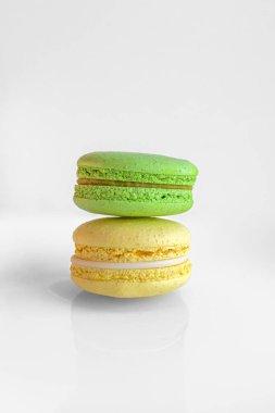 Çok renkli badem kurabiyeleri. İki yarım. Narin Fransız kurabiyeleri. Kahve tatlısı. Kurabiyeler kremaya dayanıyordu. Çıtır çıtır. İştah açıcı natürmortta renkli kurabiyeler..