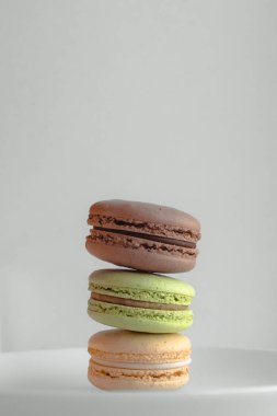 Çok renkli badem kurabiyeleri. İki yarım. Narin Fransız kurabiyeleri. Kahve tatlısı. Kurabiyeler kremaya dayanıyordu. Çıtır çıtır. İştah açıcı natürmortta renkli kurabiyeler..