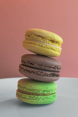 Çok renkli badem kurabiyeleri. İki yarım. Narin Fransız kurabiyeleri. Kahve tatlısı. Kurabiyeler kremaya dayanıyordu. Çıtır çıtır. İştah açıcı natürmortta renkli kurabiyeler..