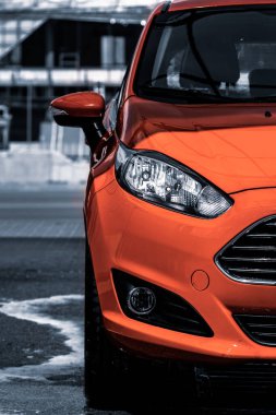 Parlak kırmızı bir araba. Otomotiv posteri. Makinenin bir parçası. Ulaşım endüstrisi. Şehir hatchback 'i. Araba yıkamacıda. Parlak kırmızı araba gün ışığında parıldıyor..