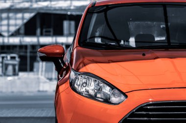 Parlak kırmızı bir araba. Otomotiv posteri. Makinenin bir parçası. Ulaşım endüstrisi. Şehir hatchback 'i. Araba yıkamacıda. Parlak kırmızı araba gün ışığında parıldıyor..