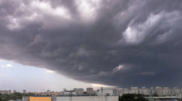 하늘은 먹구름으로 바뀌었다 하늘에서는 대조적 도시에 소리가 구름을 나르는 — 스톡 사진