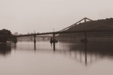 Nehirdeki köprünün ayna yansıması. Geniş bir nehir boyunca bir köprü. Şehrin Panorama 'sı. Kıyılar arası bağlantı. Avrupa köprüleri.