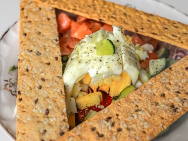 Yumurtalı ve somonlu salata ve sağlıklı bir kahvaltı olarak çavdar ekmeği. Kırmızı balıklı salata. Hafif öğle yemeği. Sağlıklı kahvaltı. Sağlıklı yaşam tarzı. Besleyici atıştırmalıklar. Salatalı bir tabak. Restoran servisi. Salata ve çok tahıllı ekmek..