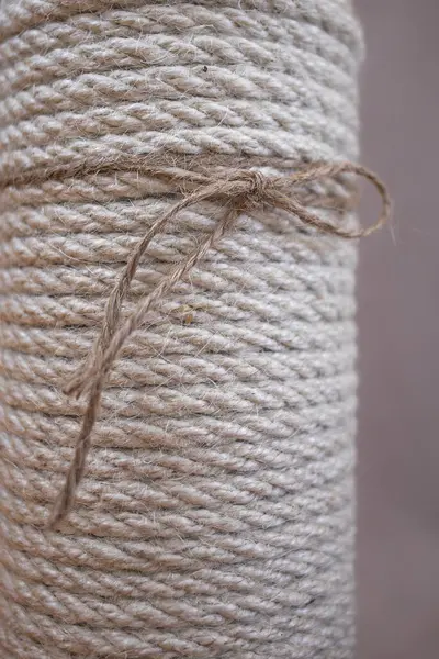Close-up of a white jute rope in a cozy interior. Twine texture. White jute vase. Fiber rope. Cozy home. Warm autumn. Natural material. Scandinavian style. Japanese interior design.