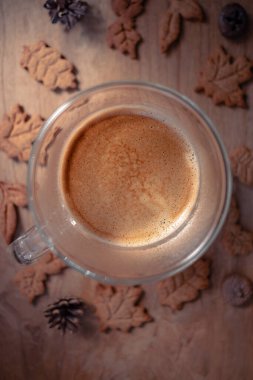 Bir fincan kahvenin üst görüntüsü. Alman Lebkuchen kurabiyeleri. Dümdüz kahve. Sonbahar yaprakları şeklinde kurabiyeler. Sonbahar arkaplanı. Kahve dükkanındaki fotoğraf. İştah açıcı natürmort. Sıcak renkler.