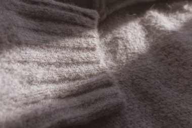Gri yün süveter deseni yakın plan. Örgü süveter. Yünlü kıyafetler. Kış sıcacık. Ev rahatlığı. Kış dönemi. Örgü deseni. Eski bir fotoğraf. Yün dokusu.